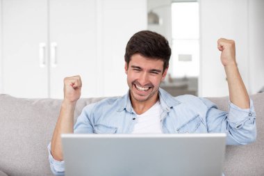 Neşeli adamın zaferi evdeki kanepede dizüstü bilgisayarda piyango kazandı.