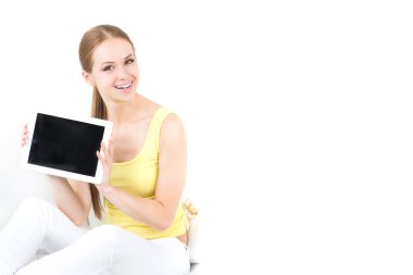 güzel kızı cama bir kanepede oturan ve elektronik tablet gösterir