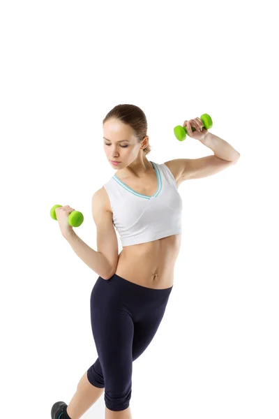 Sporting young woman is engaged with dumbbells — Stock Photo, Image