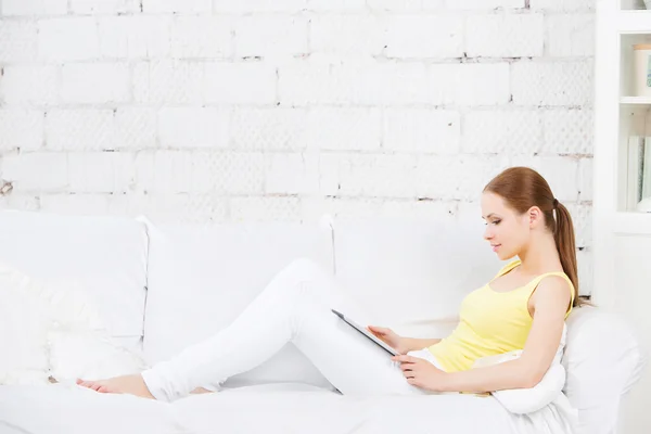 Girl on the couch with a digital tablet. Housewarming. new apartment — Stock Photo, Image