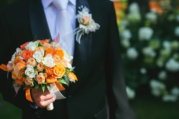 Groom está segurando buquê de noiva — Fotografia de Stock