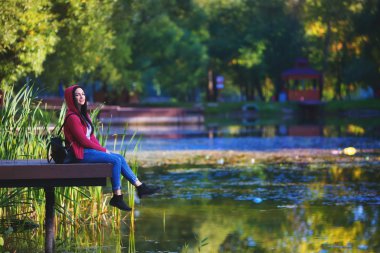 gülümseyen ve cep telefonu açık havada üzerinde konuşan genç kız 