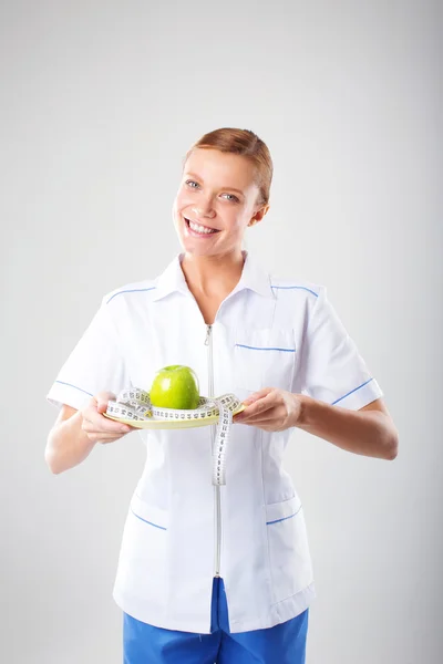 Beslenme uzmanı kadın doktor elinde bir yeşil elma — Stok fotoğraf