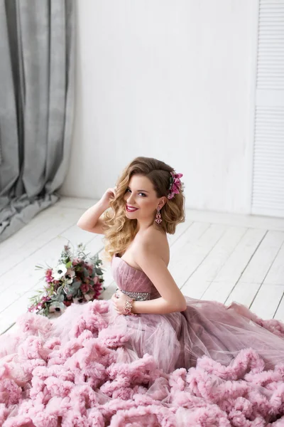 The beautiful woman posing in a wedding dress. 