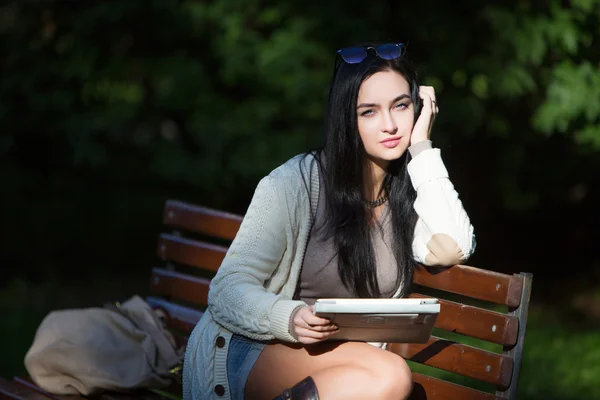 Studentin sitzt auf Bank im Park — Stockfoto