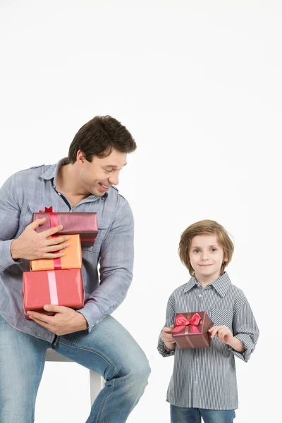 Šťastný, syn objímala jeho otec a dává mu dárek. Den otců, rodinná dovolená. — Stock fotografie
