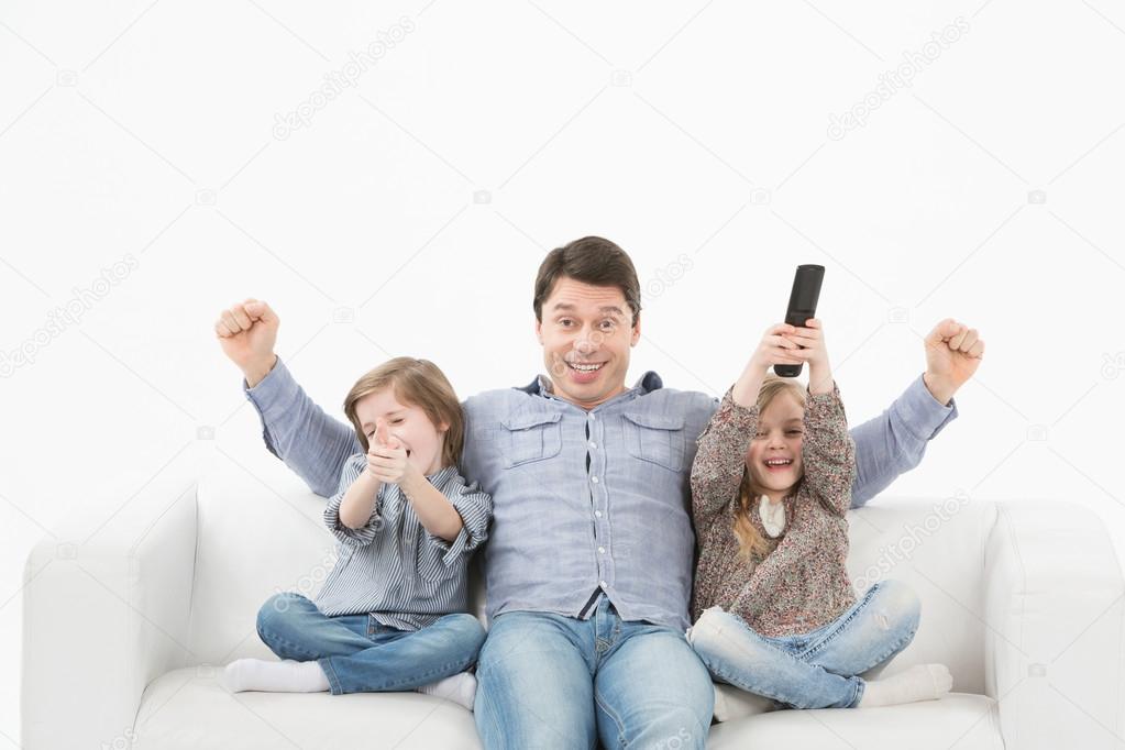 Family watching television together on the sofa