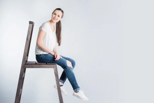 Schönes Mädchen mit langen Haaren sitzt auf der Treppe — Stockfoto