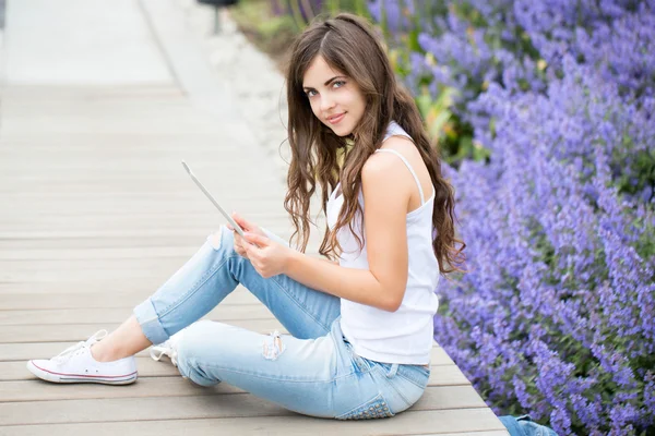 Girl holding tablet computer outdoors — Stock Photo, Image