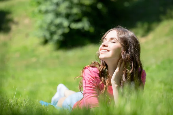 Woman lying in grass and smiling — Stock Photo, Image