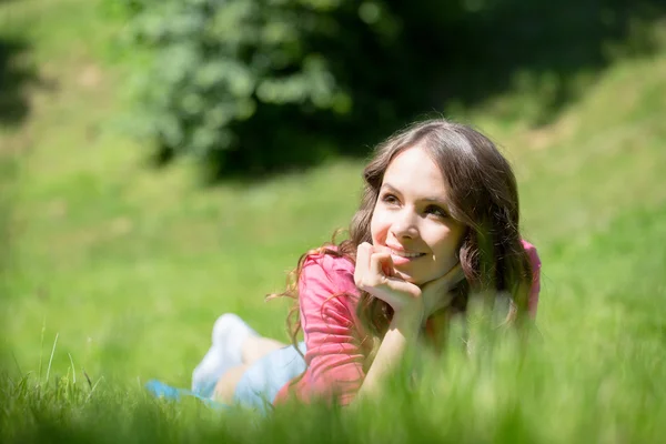 Woman lying in grass and smiling — Stock Photo, Image