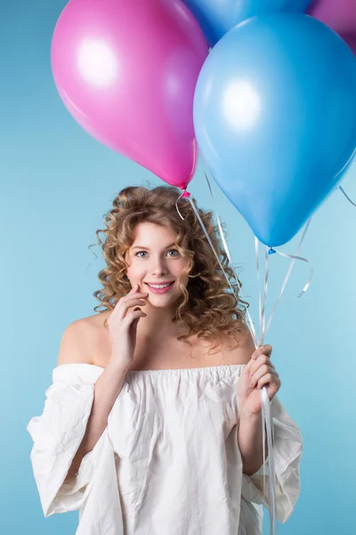 Donna con i capelli ricci che tiene palloncini — Foto Stock