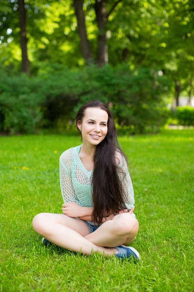 Menina em um parque na grama — Fotografia de Stock