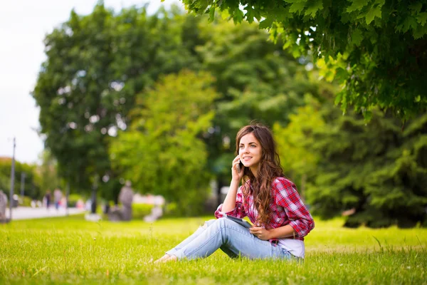 Sitting at the grass in park. — Stock Photo, Image