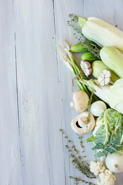 Mavi ahşap tahta üzerinde beyaz ve yeşil sebzeler. — Stok fotoğraf