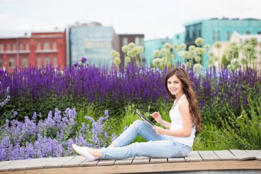 Tablet bilgisayar açık havada tutan kız