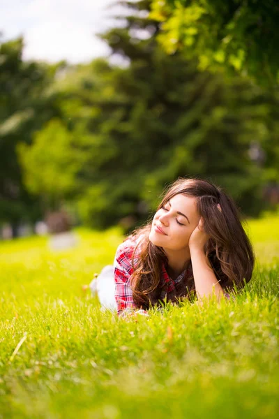 Girl student enjoys lying on green grass. — Stock Photo, Image
