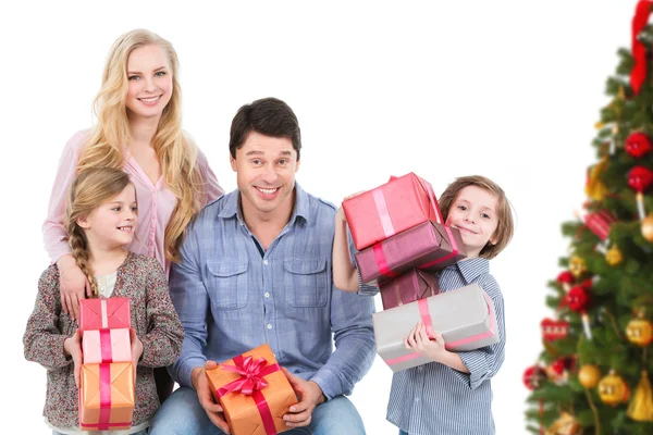 Família feliz com presentes perto de uma árvore de Natal . — Fotografia de Stock