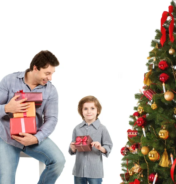 Homem e criança com presentes de Natal perto de uma árvore de Natal . — Fotografia de Stock