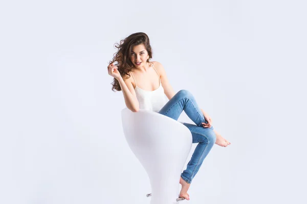 Retrato de una hermosa joven sentada en una silla . — Foto de Stock