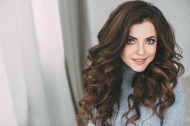 Uzun kıvırcık saçlı güzel kadın. Saç ve makyaj.