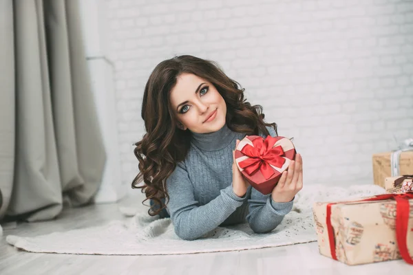 Hermosa morena mirando rojo regalo caja corazón . —  Fotos de Stock