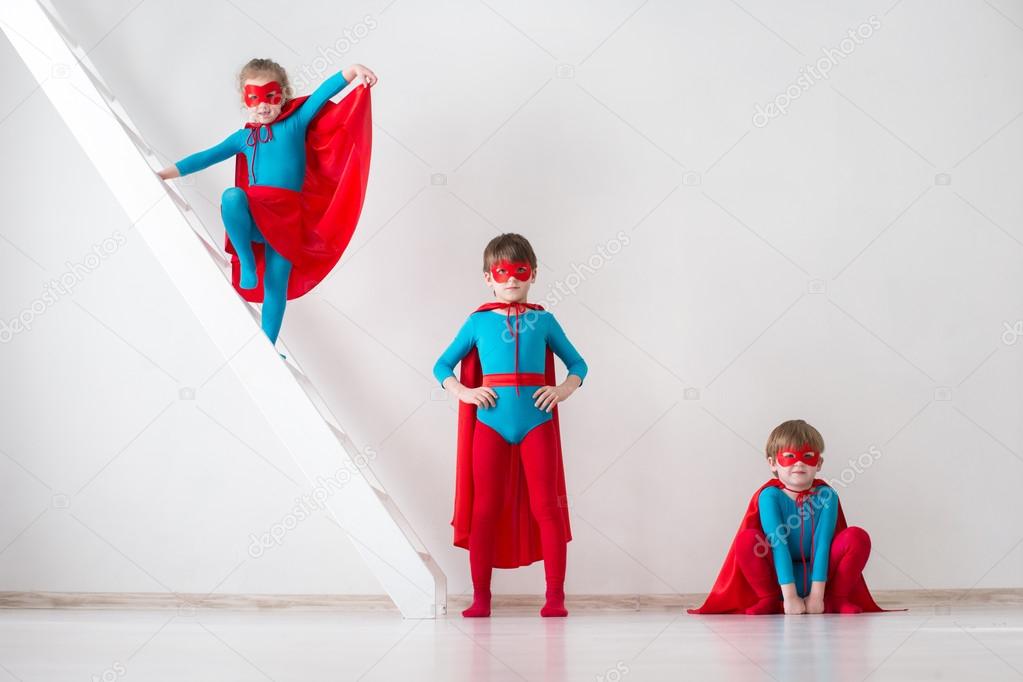 Children playing as superheroes with red coats