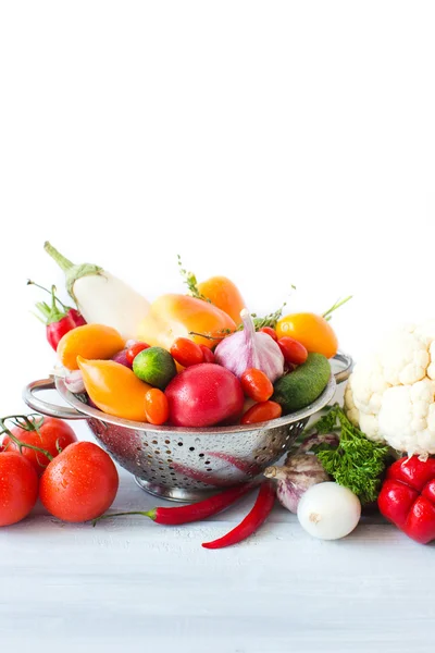 Legume proaspete în colander metalic peste alb . — Fotografie, imagine de stoc