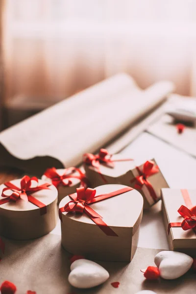 Caixas de presente Kraft com fitas vermelhas na mesa . — Fotografia de Stock