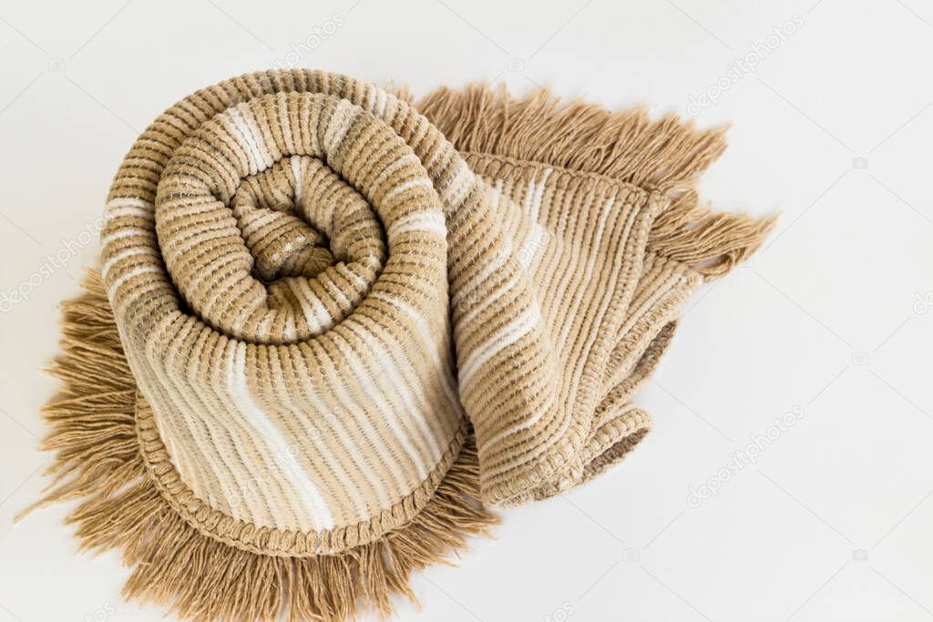 Double size one brown color  rolled wool blanket on white surface with copy space