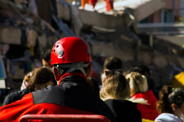 Arama ve kurtarma görevlisinin arkası depremde yıkılan binanın önünde bulanıklaştı.