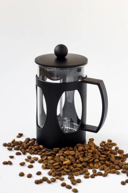 Siyah renk, beyaz arkaplanda kahve makinesi ve kahve çekirdekleri var.