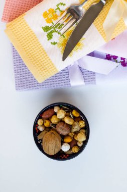 Renkli, geleneksel işlemeli mutfak havluları beyaz yüzeyde fındıklı.