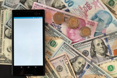 Türk Lirası ve Amerikan Doları üzerinde beyaz ve boş ekranlı akıllı telefon, üst görünüm