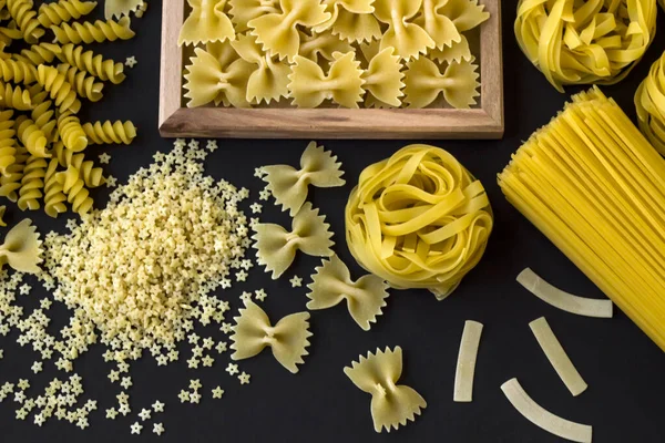 Blandad Okokt Pasta Designad Svart Bakgrund Med Rosett Stjärnformad Pasta — Stockfoto