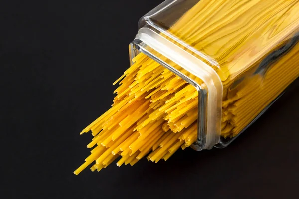 Okokt Torr Olika Storlekar Spaghetti Pasta Lång Glasburk Svart Yta — Stockfoto