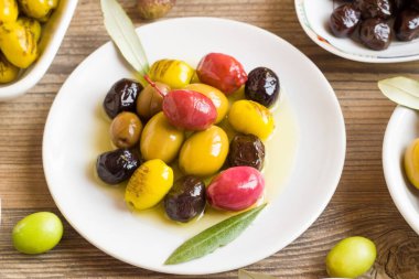 Türk Mutfağı 'nın zeytin çeşitleri ahşap yüzeyde beyaz bir tabakta dizayn edilmiştir.