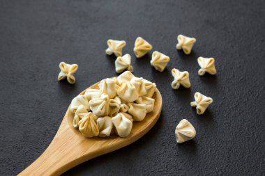 Beyaz zemin üzerine ahşap kaşıkla dizayn edilmiş kıymalı geleneksel Türk köfteleri.