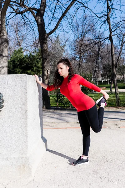 Frau streckt ihr Bein in einem Park — Stockfoto