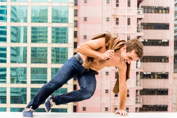 Man jumping a Corbel of a Rooftop — Stock Photo, Image