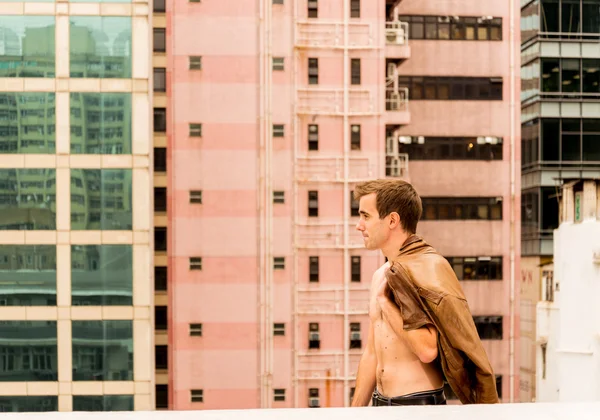 Homem andando com um casaco em um telhado — Fotografia de Stock