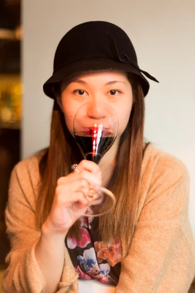 Carino ragazza asiatica bere un bicchiere di vino rosso — Foto Stock