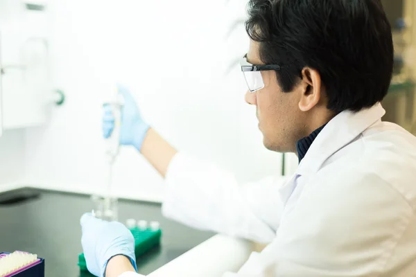 Bir pipet ile çalışan araştırmacı