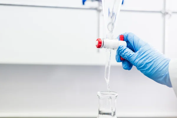 Mujer trabajando con un embudo en un laboratorio — Foto de Stock