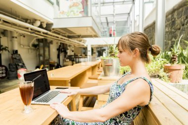 Çalışma ve buzlu bir kahve olan kadın