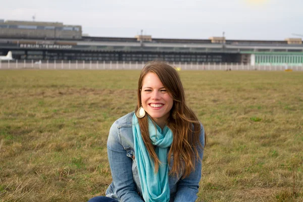 Lachende meisje, zittend op het gras in Berlin-Tempelhof — Stockfoto