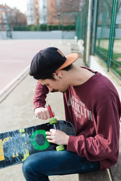 Homem reparando seu patins — Fotografia de Stock