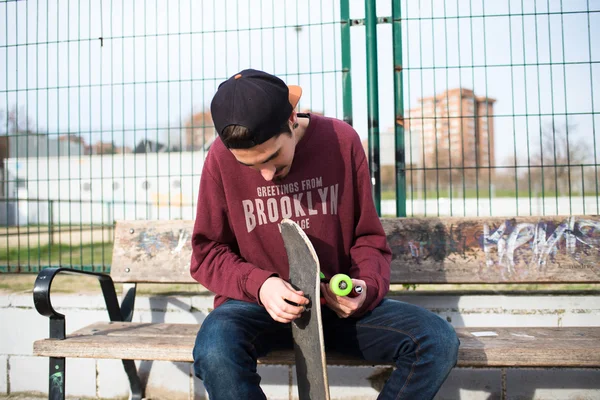 Sur la rue en train de réparer son Skate — Photo