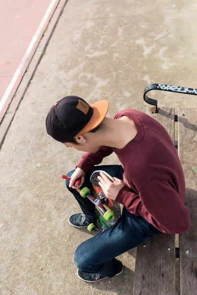 Overhead: Homem reparando seu Skate — Fotografia de Stock