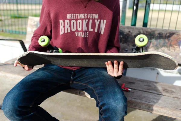 Dude kontrollera sin Skate på gatan — Stockfoto